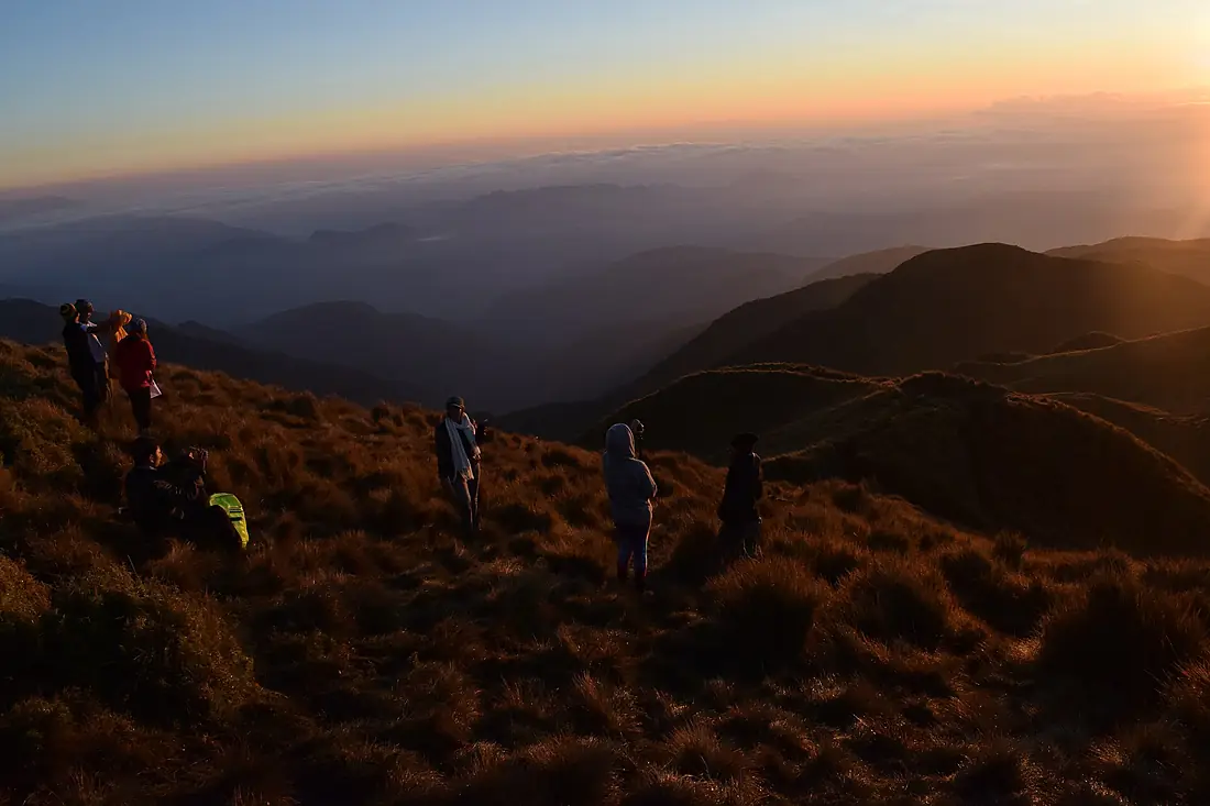 Hikers watching sunrise at Mount Pulag summit