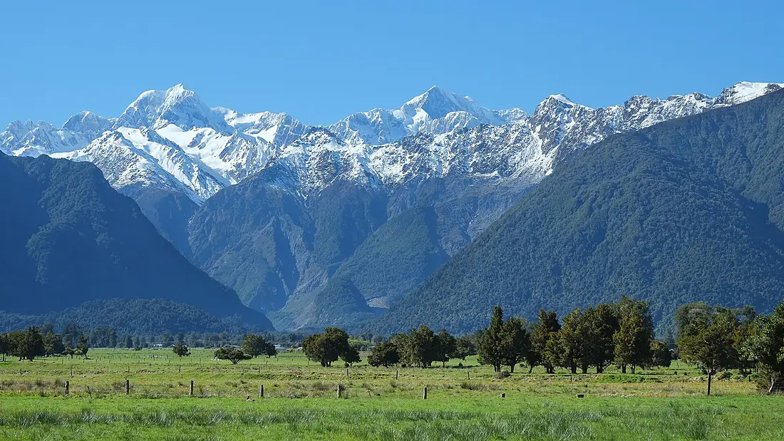 Fox Valley entrance with Mount Tasman and Aoraki Mount Cook behind and paddocks in front